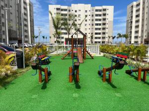 a park with a playground with a swing set at Vila dos Ventos in São Pedro da Aldeia