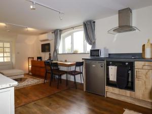 a kitchen and living room with a table and chairs at The Hideaway in Tintagel