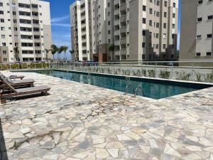 a swimming pool in a city with tall buildings at Vila dos Ventos in São Pedro da Aldeia