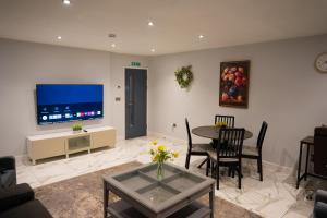 a living room with a table and a tv at Westfield luxurious Apartment in Birmingham