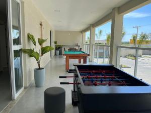 a large room with a pool table with cue balls at Vila dos Ventos in São Pedro da Aldeia