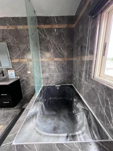 a bath tub in a bathroom with a window at Casa tequila club jacuzzi 4 in Arandas