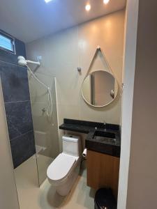 a bathroom with a toilet and a shower and a mirror at Pousada Complexo Vibe in Baraúna