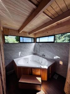 a large bath tub in a room with windows at Cabañas Refugio del Lago in El Cerrillo +25 photos