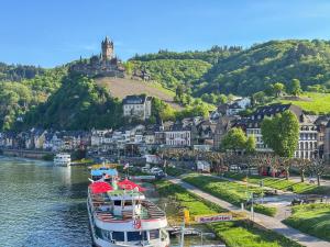 Ein Boot liegt in einem Fluss neben einer Stadt vor Anker. in der Unterkunft Cochem in Cochem