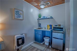 a small kitchen with blue cabinets and a stove at Fjordline Lodge in Hoodsport