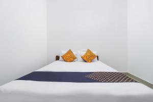 a bed with orange and blue pillows on it at SPOT ON Rohini Inn Kadampuzha in Malappuram +28 photos
