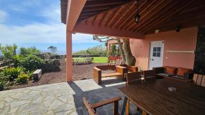an outdoor patio with a wooden table and chairs at Quinta das Candeias in Candelária