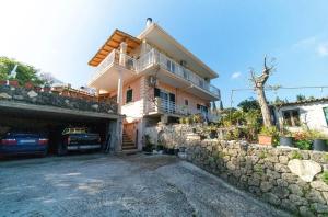 a house with a car parked in front of it at Kalemi House, Spacious 2BR Home with Garden near Ipsos and Dassia in Kato Korakiana