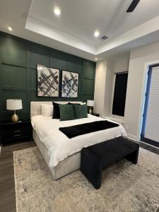 a bedroom with a large bed with a green wall at The Grand Harris in Houston
