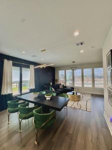 a living room with a table and green chairs at The Grand Harris in Houston
