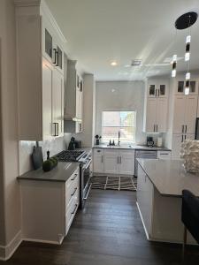 a large kitchen with white cabinets and a kitchen island at The Grand Harris in Houston