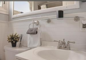a white bathroom with a sink and a toilet at Bruno's Landing in Kansas City +18 photos