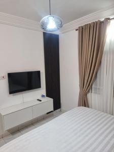 a bedroom with a bed and a tv on the wall at OD-VICK'S PLUSH STUDIOS, Utako in Abuja
