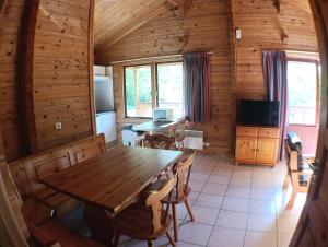 a dining room with a wooden table and chairs at Le Havre Sylvestre Séjour nature avec piscine in Mauroux