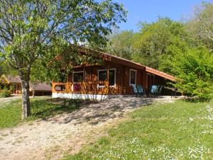 a house with a porch and chairs in front of it at Le Havre Sylvestre Séjour nature avec piscine in Mauroux