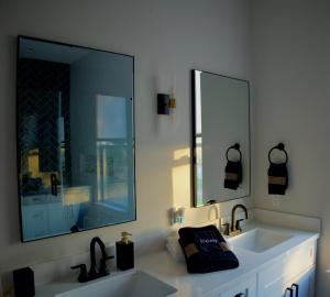 a bathroom with two sinks and a large mirror at The Grand Harris in Houston +28 photos