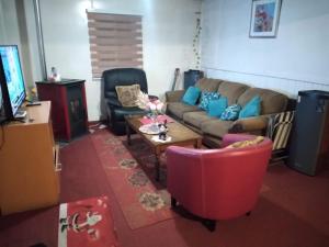 a living room with a couch and a table and chairs at Hospedaje Domiluis in Coihaique