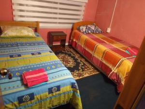 a room with two beds in a room at Hospedaje Domiluis in Coihaique