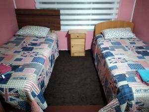 two beds sitting next to each other in a room at Hospedaje Domiluis in Coihaique +1 photo