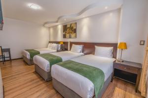 a hotel room with two beds and a table at Zamorano Real Hotel in Loja