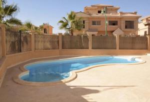 a swimming pool in front of a house at Katameya Palms in Cairo