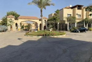 a house with a garden in the middle of a parking lot at Katameya Palms in Cairo