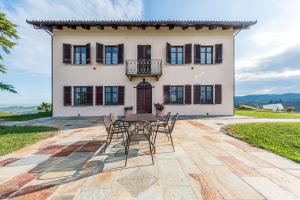 a table and chairs in front of a house at Villa Bricco Paglieri in Alba