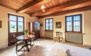 a bedroom with a table and a bed and windows at Villa Bricco Paglieri in Alba