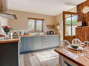 a kitchen with blue cabinets and a wooden table at 2 Bed in Wells oc-90425 in Croscombe