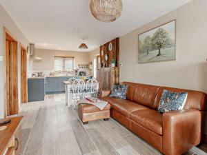 a living room with a brown leather couch and a kitchen at 2 Bed in Wells oc-90425 in Croscombe