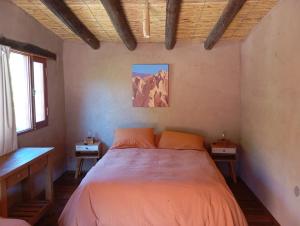 a bedroom with a large bed with orange pillows at Los Amarantos in Tilcara