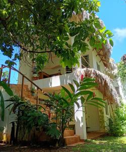 a white house with a gate and trees at Quédate Aquí in Las Galeras