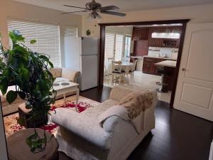 a living room with a couch and a kitchen at As You Wish Suites & Rooms Near YVR with Parking in Richmond