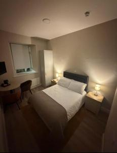 a bedroom with a bed and a desk with two lamps at Wild Atlantic Inn in Lisdoonvarna