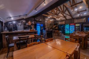 a restaurant with wooden tables and chairs and a bar at Tiny & Big House Suite Los Mallines de Malalcahuello in Malalcahuello