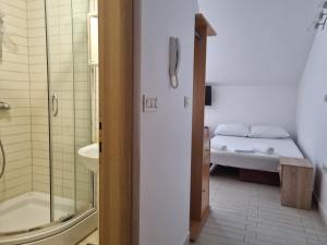 ein Badezimmer mit Bett, Dusche und Waschbecken in der Unterkunft View - Novalja in Novalja