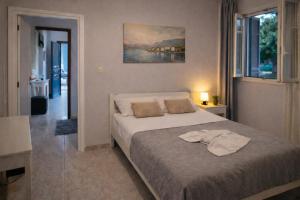 ein Schlafzimmer mit einem Bett und einem Gemälde an der Wand in der Unterkunft Alexandra Studios in Stafylos