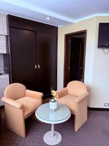 a living room with two chairs and a table at Suites Edificio Akros in Quito