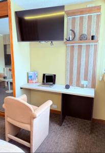 a desk with a laptop and a chair in a room at Suites Edificio Akros in Quito