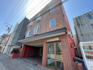 a red brick building on a city street at サイプレス平岸 in Sapporo