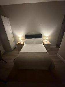 a bedroom with a large bed with two lamps on both sides at Wild Atlantic Inn in Lisdoonvarna
