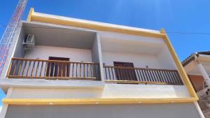 a white building with wooden balconies on it at Casa Mandala Canoa Quebrada in Aracati