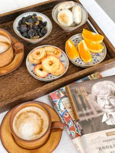 a tray of food with cups of coffee and fruit at Dunhuang County Posthouse in Dunhuang