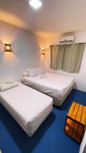 a room with three beds and a window at Casa Mandala Canoa Quebrada in Aracati +24 photos