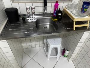 a kitchen sink with two empty wine glasses and a stool at Ap FIG Garanhuns in Garanhuns
