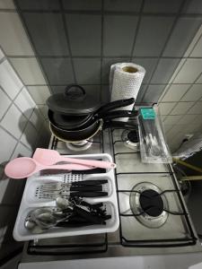 a stove top with a pan and utensils on it at Ap FIG Garanhuns in Garanhuns