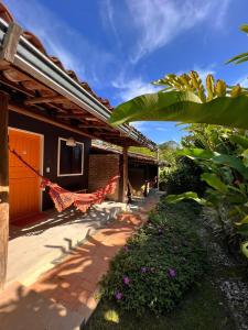 a house with a hammock hanging off the side of it at Biribandos Rooms - a 300 metros do Quadrado e 900 metros das praias in Trancoso