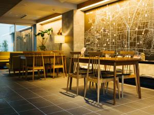 a restaurant with wooden tables and chairs and a map on the wall at KéFU stay & lounge in Kyoto