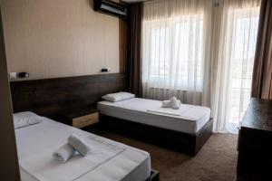 a hotel room with two beds and two windows at Hotel Istatov in Nov Dojran +26 photos